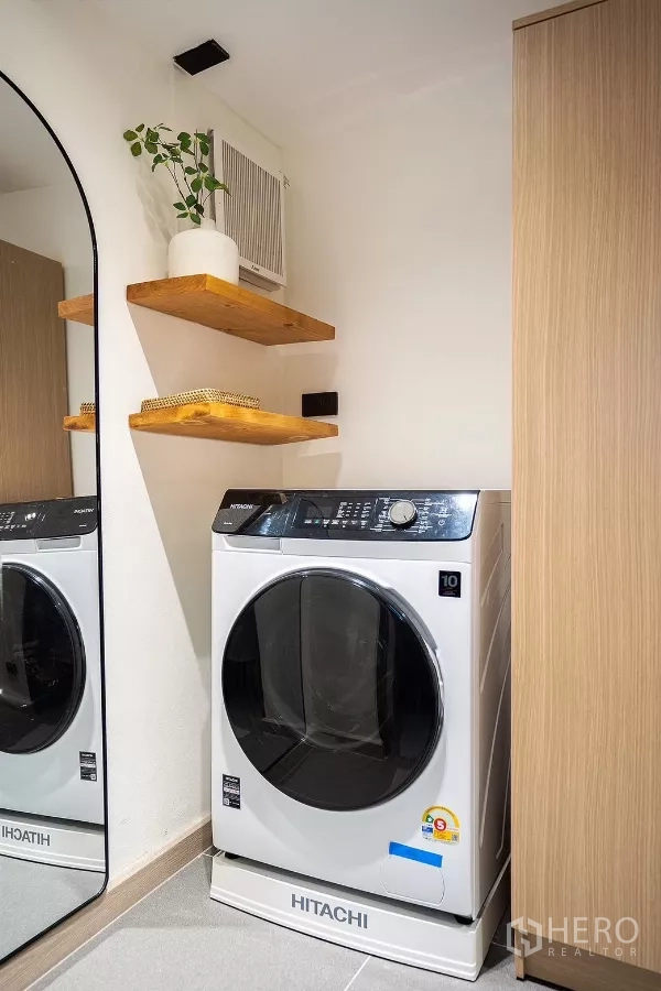Detached House for rent in Huai Khwang, Bangkok - Laundry corner with front-load washing machine, mirror and wood shelves.