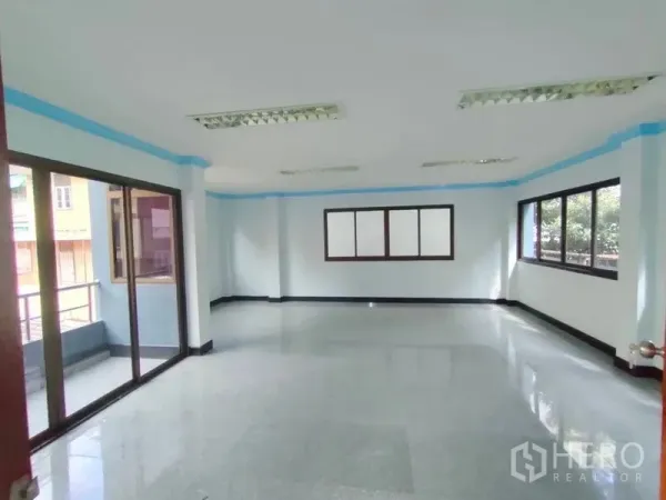 Home Office for rent in Pathum Wan, Bangkok - Spacious open-plan office floor with large windows and a sliding door to the balcony.