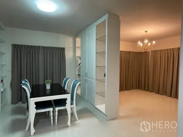 Detached House for sale in Khlong Toei, Bangkok - Cozy dining area with four-seat table beside tall white storage and shelves.