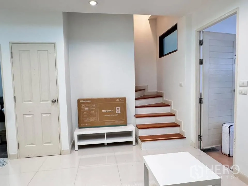 Townhouse for rent in Phra Khanong, Bangkok - Ground floor view with staircase and doors off the living area.