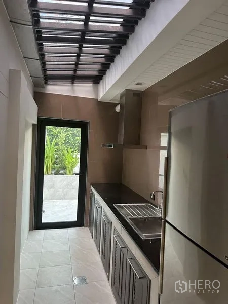 独立式住宅 出租在Suan Luang, Bangkok - 后备泰式厨房，采光顶棚并可通往露台。