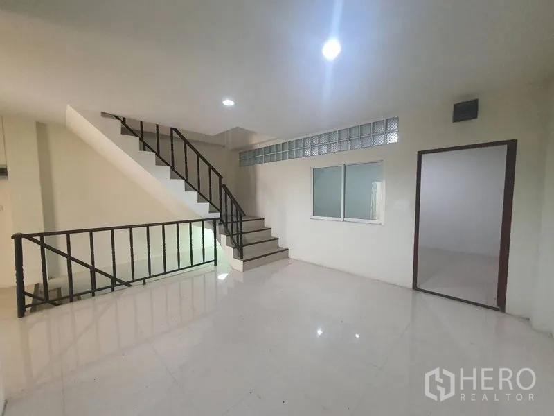 Home Office for rent or sale in Yan Nawa, Bangkok - Landing area with stairs, windowed partition and doorway to an office room.