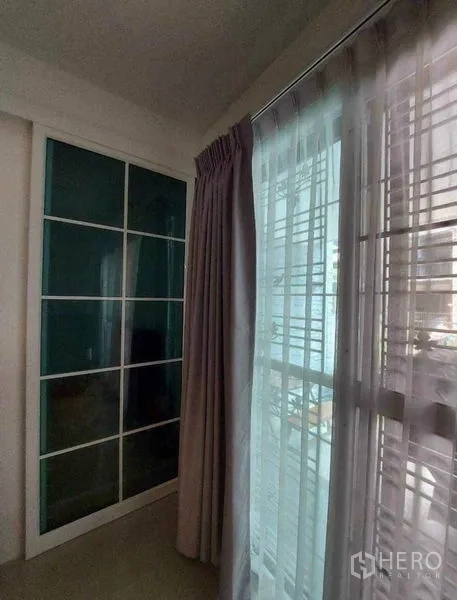 联排别墅 出租在Bang Phli, Samut Prakan - 卧室一角，落地窗帘与玻璃推拉衣柜门。