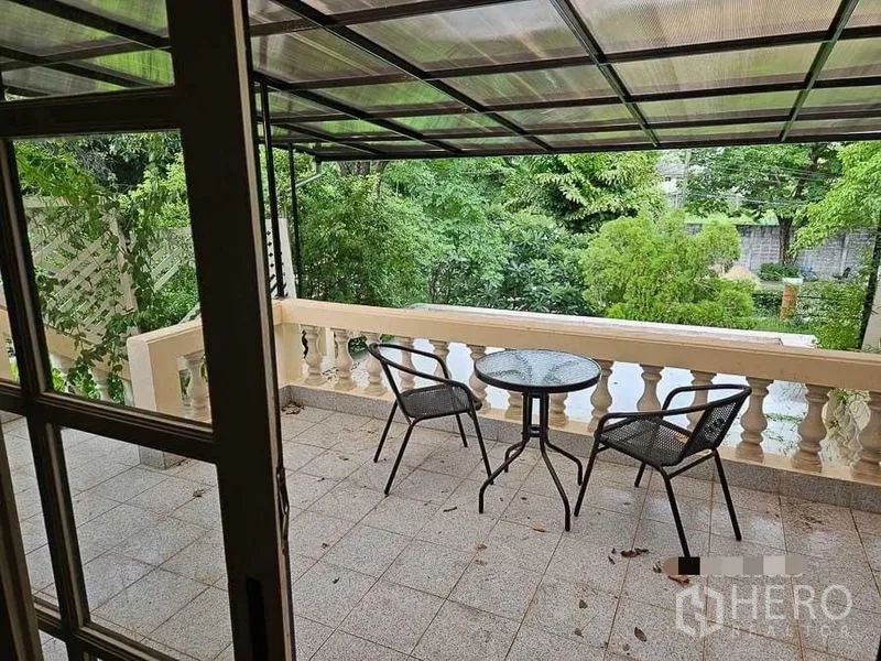 Detached House for rent - Covered balcony with bistro table and chairs overlooking a leafy garden.