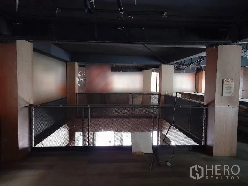 Shophouse for rent - Mezzanine level with metal railing overlooking the ground floor and industrial ceiling services.