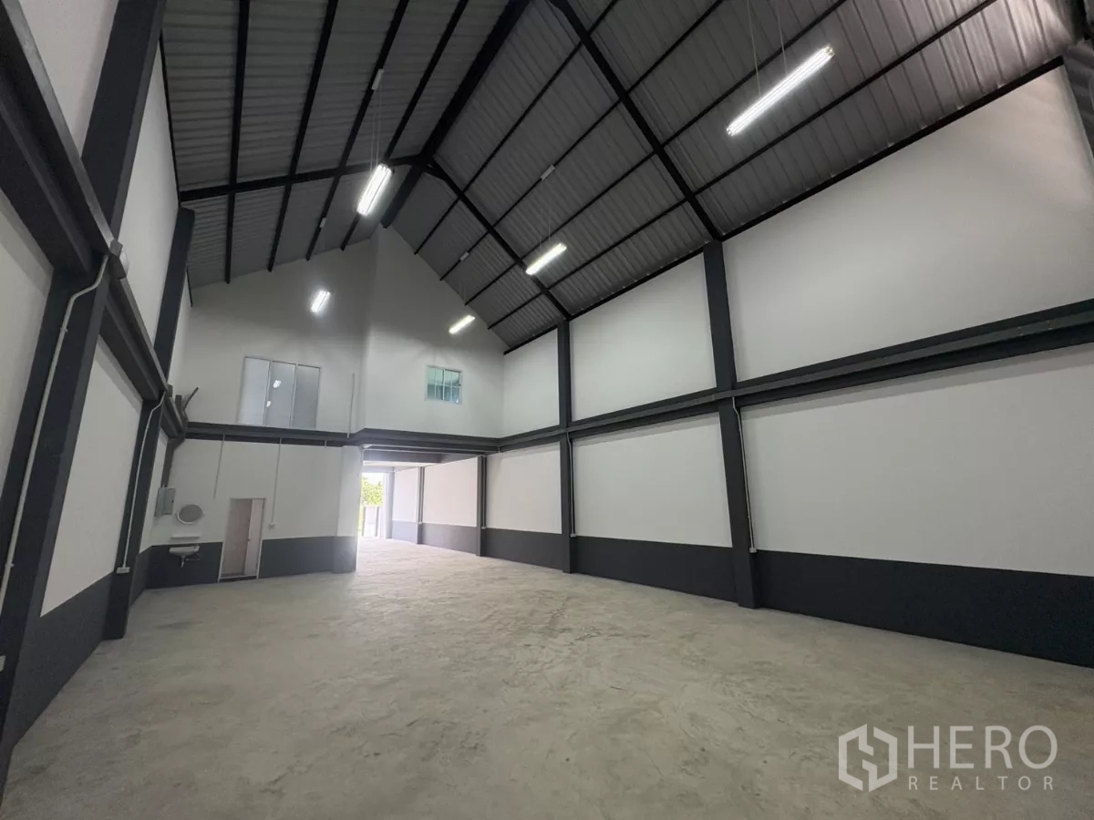 Factory for rent or sale in Bang Bua Thong, Nonthaburi - Warehouse interior with tall ceiling, mezzanine windows, sink and restroom access.