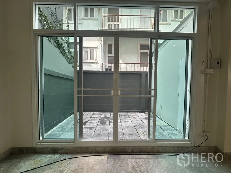 Home Office for rent in Khlong Toei, Bangkok - Sliding glass doors opening to a private tiled courtyard.