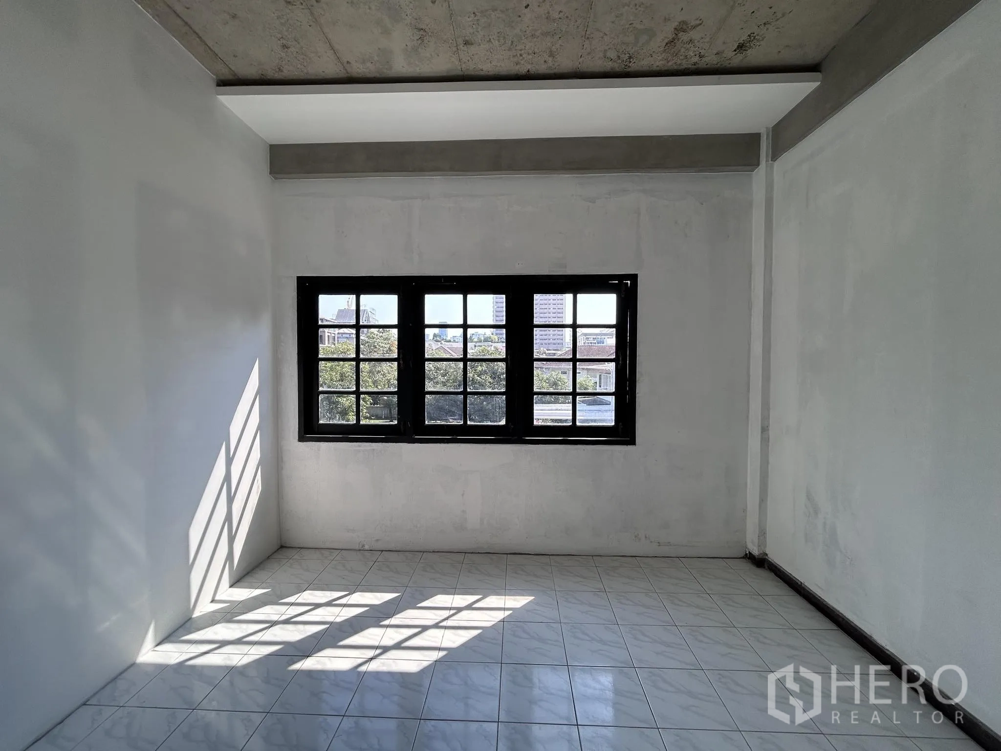 Home Office for rent or sale in Watthana, Bangkok - Bright tiled room with central window overlooking the neighborhood.