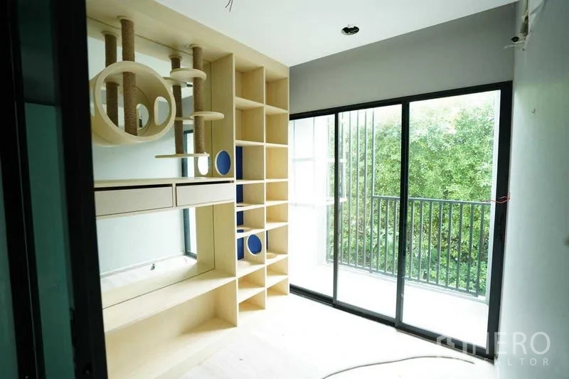 Standalone for rent in Bang Na, Bangkok - Room with custom shelving and circular niches beside balcony sliding doors.