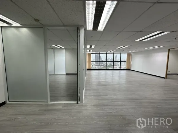 Office Space for rent in Watthana, Bangkok - Sliding glass door to a meeting room beside a large open workspace with panoramic Bangkok windows.