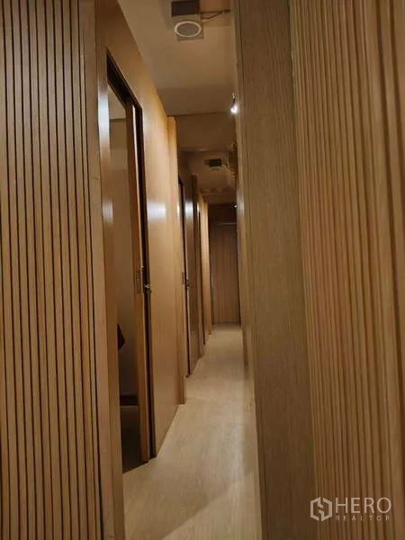 Shophouse for rent or sale in Watthana, Bangkok - Narrow hallway lined with wooden doors to treatment rooms.