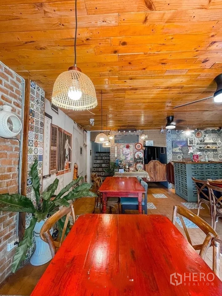 Retail Space for rent in Watthana, Bangkok - Dining area featuring rattan pendant lamps, wood ceiling, red tables, and leafy plants.