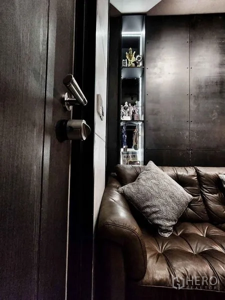 Condominium for sale in Pathum Wan, Bangkok - Close-up of leather sofa beside the entrance door and a lit display niche.