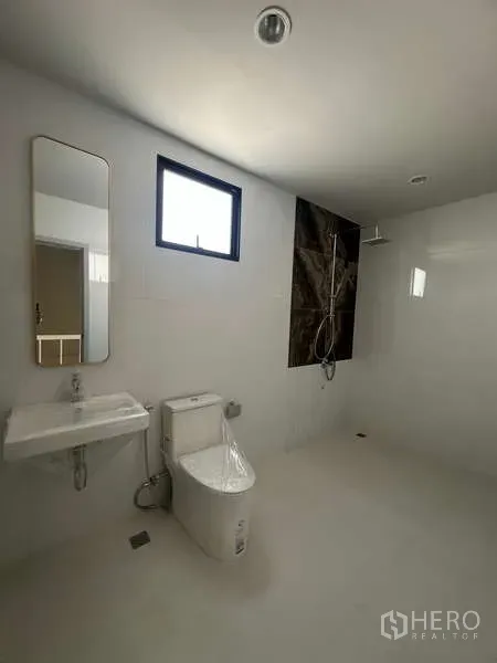 Factory for sale in Lam Luk Ka, Pathum Thani - Clean restroom with walk-in shower, toilet, sink and small window.