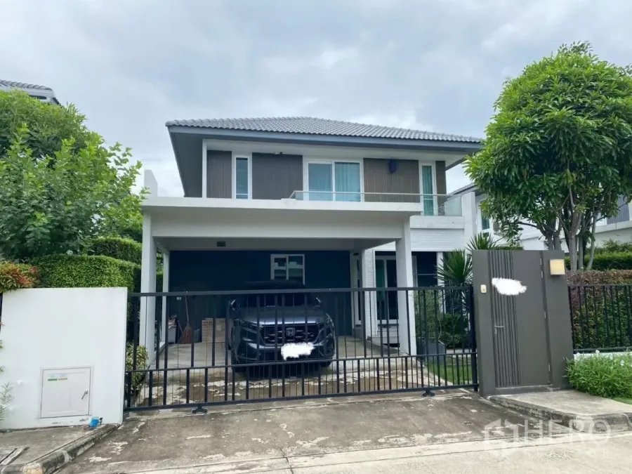 Detached House for rent in Prawet, Bangkok - Modern two-storey detached house with gated carport and landscaped frontage.