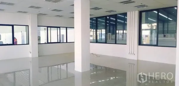 Factory for rent in Mueang Rayong, Rayong - Bright office area with tiled floor, suspended ceiling and large windows overlooking the production hall.