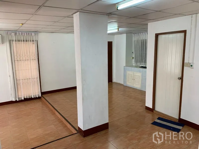 Office Space for rent in Chatuchak, Bangkok - Columned workspace with a step-down zone and a compact pantry counter by the window.
