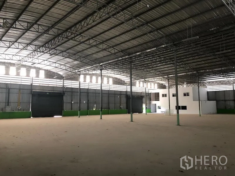 Warehouse for rent in Lat Krabang, Bangkok - Open floor warehouse showing multiple roller shutter loading doors, clerestory windows and wide column spacing.