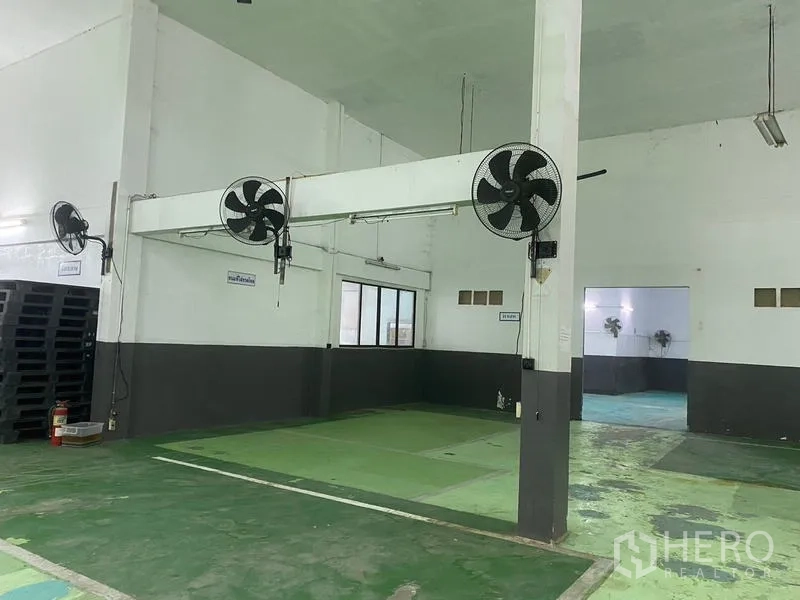 Warehouse for rent in Lam Luk Ka, Pathum Thani - Interior bay with industrial wall fans and support columns