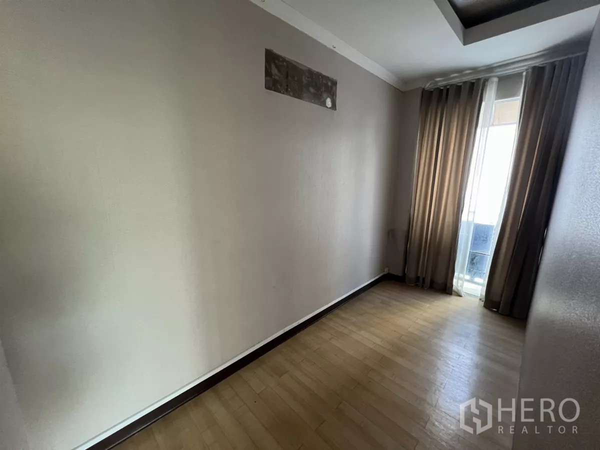 Retail Space for rent - Narrow room with curtain and balcony door, light wood floor.