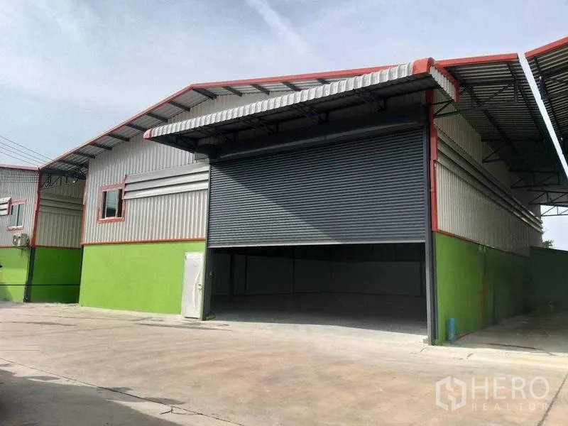 货栈 出租在Bang Khun Thian, Bangkok - 仓库外立面，带大型卷闸门与遮雨装卸区
