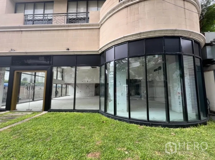 Retail Space for rent in Watthana, Bangkok - Corner retail facade with curved floor-to-ceiling glass and lawn frontage.