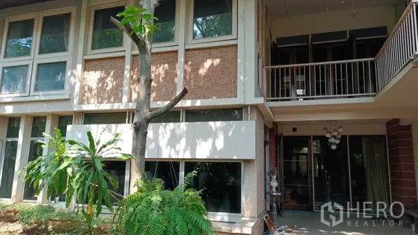Detached House for rent in Phaya Thai, Bangkok - Two-storey detached house exterior with large windows, balcony and shaded garden in Phaya Thai.