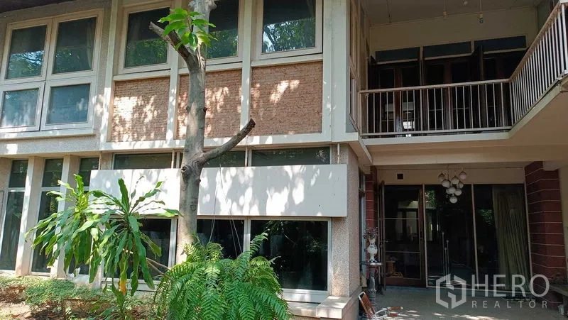 Detached House for rent in Phaya Thai, Bangkok - Two-storey detached house exterior with large windows, balcony and shaded garden in Phaya Thai.