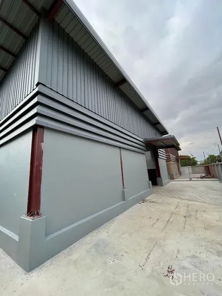 Warehouse for rent in Khlong Sam Wa, Bangkok - Modern metal-clad warehouse exterior with high eaves and a concrete loading yard in Khlong Sam Wa, Bangkok.