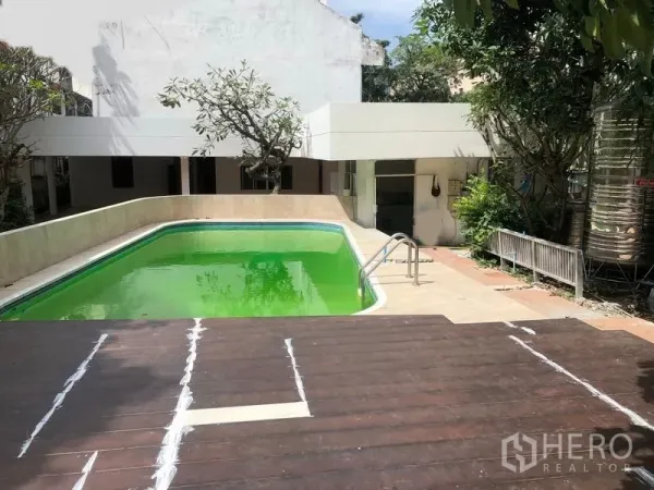 Detached House for rent in Watthana, Bangkok - Private swimming pool with deck and surrounding greenery in urban garden.