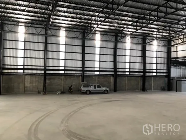 Warehouse for rent in Khlong Toei, Bangkok - Large storage area with steel columns, translucent wall panels and vehicle access suitable for trucks.