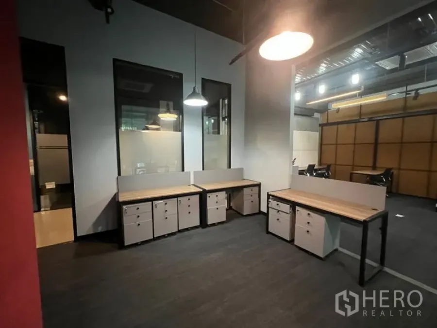 办公空间 出租 - 开放式办公室，木质桌面与抽屉柜，工业风吊灯与玻璃分隔。