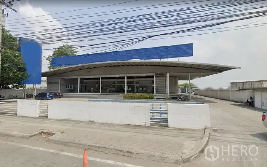 货栈 出租在Bang Phli, Samut Prakan - Bang Phli 现代仓库外观，弧形大雨棚、闸门入口与宽敞车道。