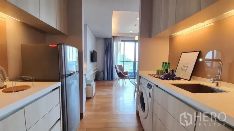 Condominium for rent in Khlong Toei, Bangkok - Alternate view of the galley kitchen featuring refrigerator and washing machine.