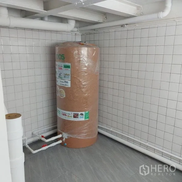 Shophouse for rent in Khlong Toei, Bangkok - Utility corner with new water tank and white tiled walls, ready for operations.