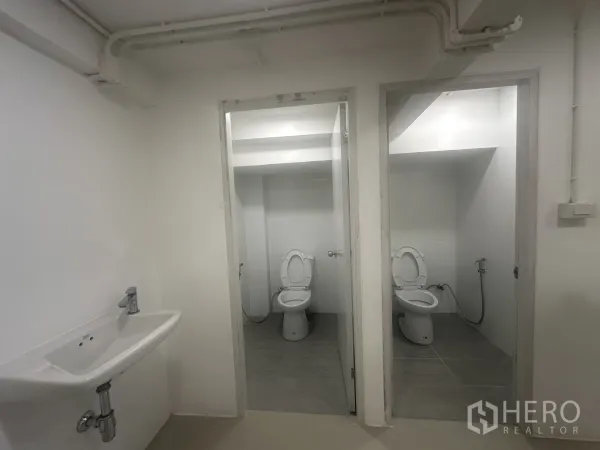 Retail Space for rent - Two separate toilet rooms with fixtures and spray hoses, basin outside.