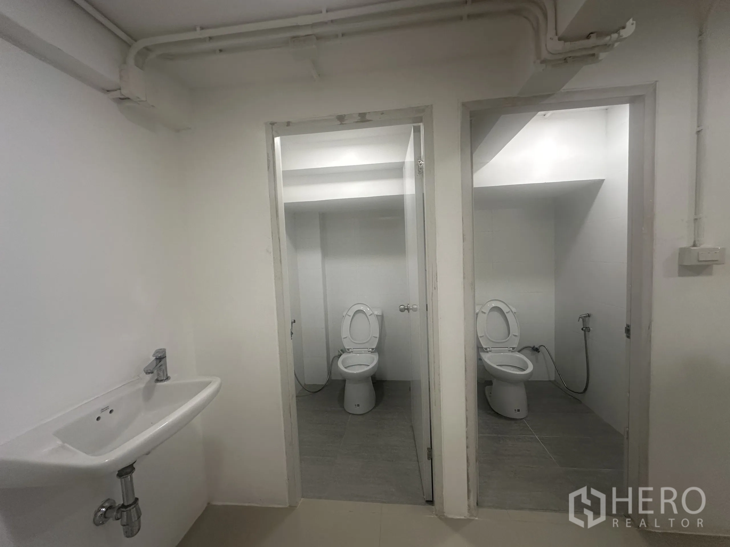 Retail Space for rent - Two separate toilet rooms with fixtures and spray hoses, basin outside.