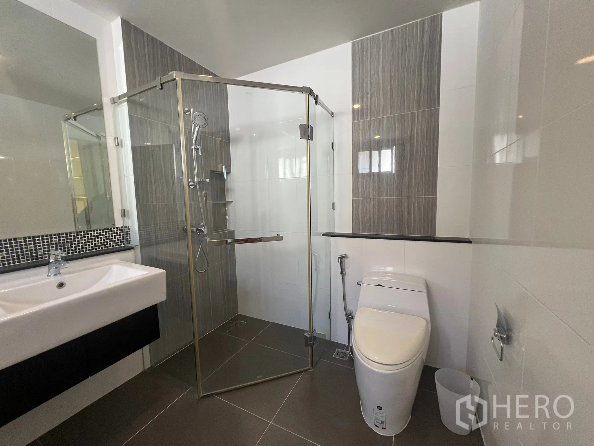 Detached House for rent or sale in Prawet, Bangkok - Bathroom with glass shower enclosure, toilet and vanity.