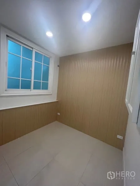 Home Office for rent - Small private office with window, downlights, and beige wall panels.