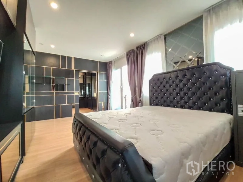 Detached House for rent - Master bedroom with tufted bed, wood flooring and balcony doors with draped curtains