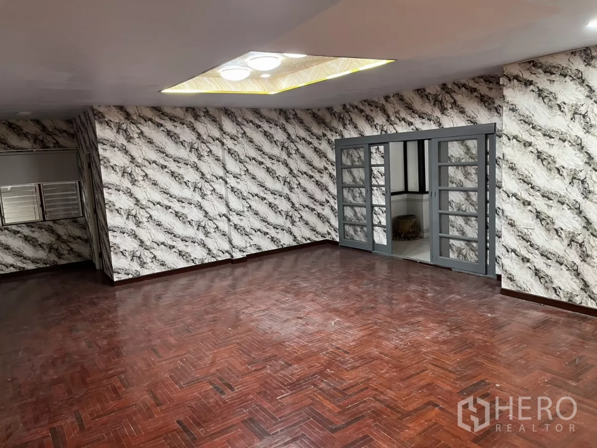 独立式住宅 出租在Watthana, Bangkok - 大型会客厅，特色墙面、嵌入式照明与推拉玻璃门。