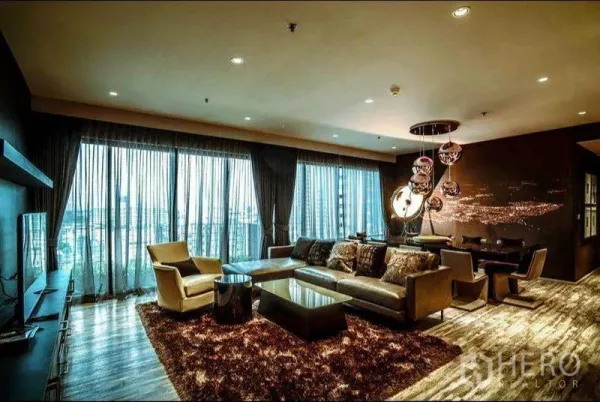 Condominium for rent or sale in Khlong Toei, Bangkok - Spacious living and dining area with floor-to-ceiling windows, plush rug and contemporary lighting.