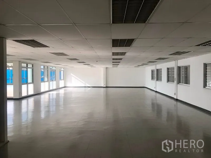 Factory for rent or sale in Bang Pa-in, Phra Nakhon Si Ayutthaya - Expansive open-plan office floor with grid ceiling, tiled flooring and ample windows.