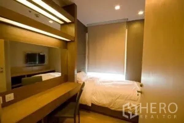 Condominium for rent in Khlong Toei, Bangkok - Cozy second bedroom with single bed, long built-in desk, mirror and blackout blinds.