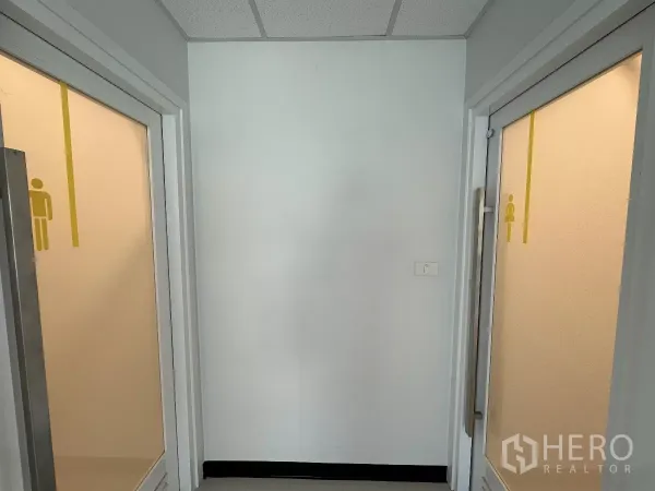 Office Space for rent in Watthana, Bangkok - Separate men’s and women’s restroom entrances with frosted glass doors in the office corridor.