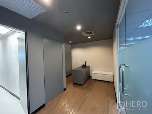 Office Space for rent in Chatuchak, Bangkok - Reception corner with glass door, desk and white sofa in a modern office.