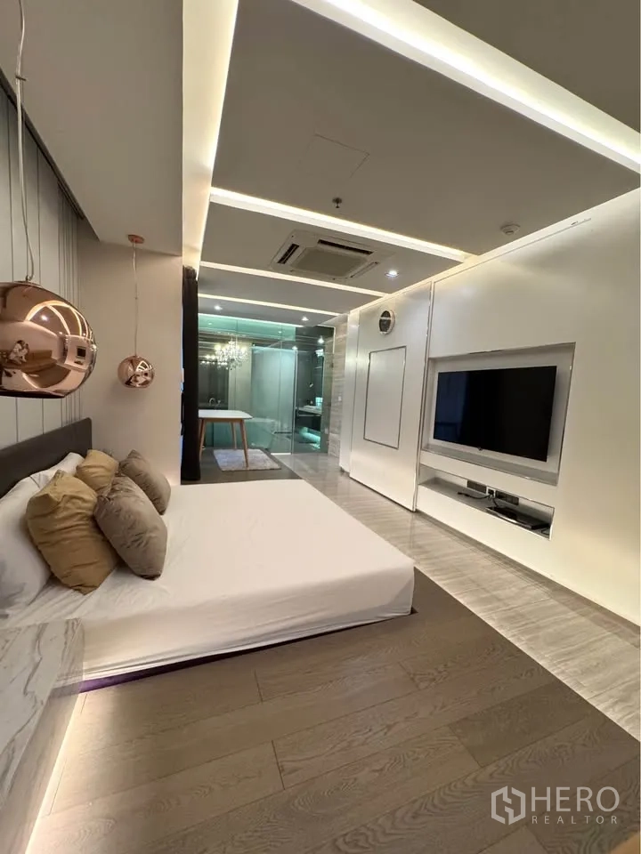 Condominium for rent or sale in Khlong Toei, Bangkok - Master bedroom media wall facing the bed with a view into the bathroom.