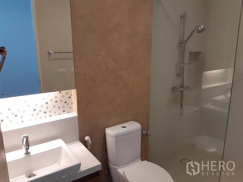 Condominium for rent or sale in Khlong Toei, Bangkok - Guest bathroom shower with glass partition and wall-mounted shower set.