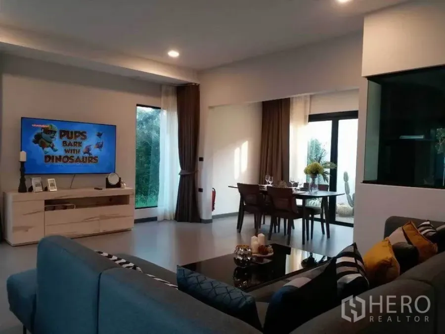 联排别墅 出租在Bang Phli, Samut Prakan - 开放式客餐厅，转角沙发、壁挂电视与大窗