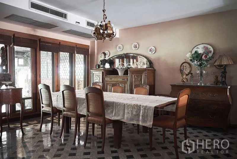 Townhouse for rent in Khlong Toei, Bangkok - Formal dining room with long table, chandelier and antique sideboard